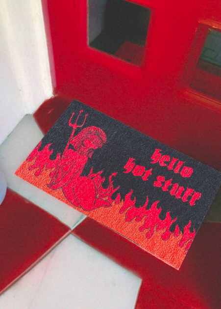 Red and black mat with a Lucy artwork and flames that says &quot;hello hot stuff&quot;