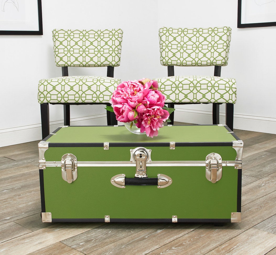The green trunk in front of green patterned chairs