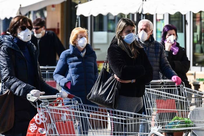 People waiting outside a grocery store with face masks on