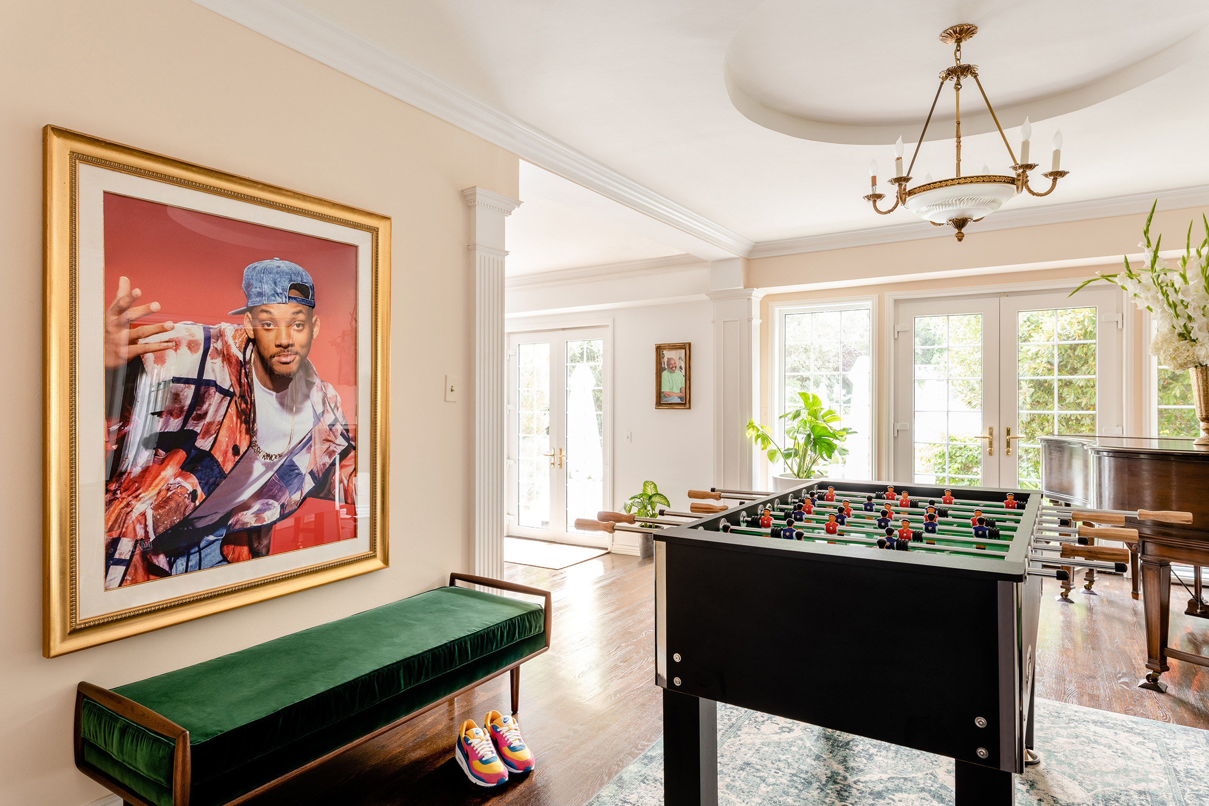 A room filled with a foosball table, piano, and a framed photo of Will Smith (à la Fresh Prince) on the wall