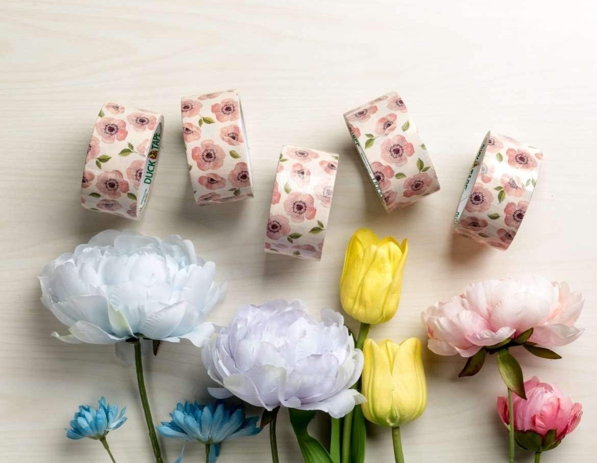 A set of duct tape with flower prints on a background with real flowers as decoration