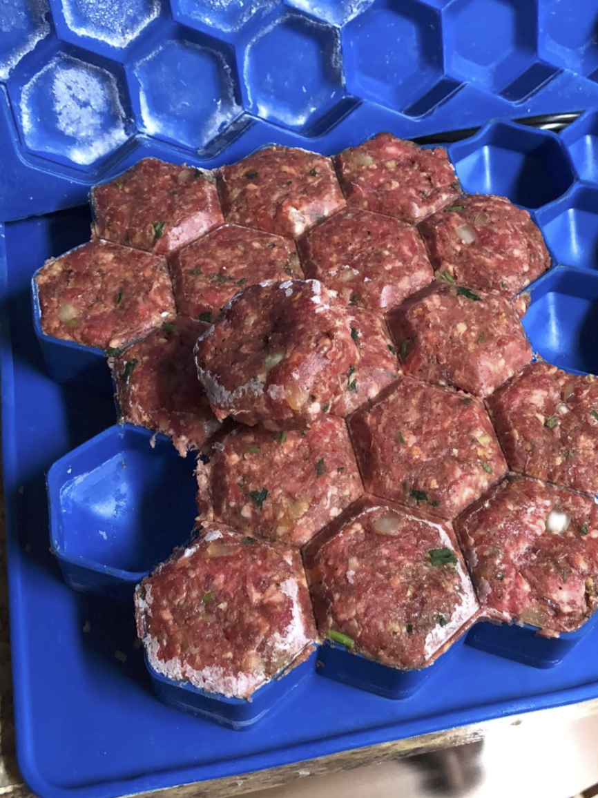beef with seasoning and veggies that has been packed into the meatball maker