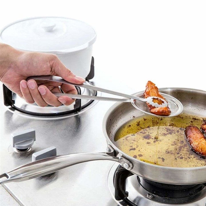 A hand frying a snack using the filter spoon.