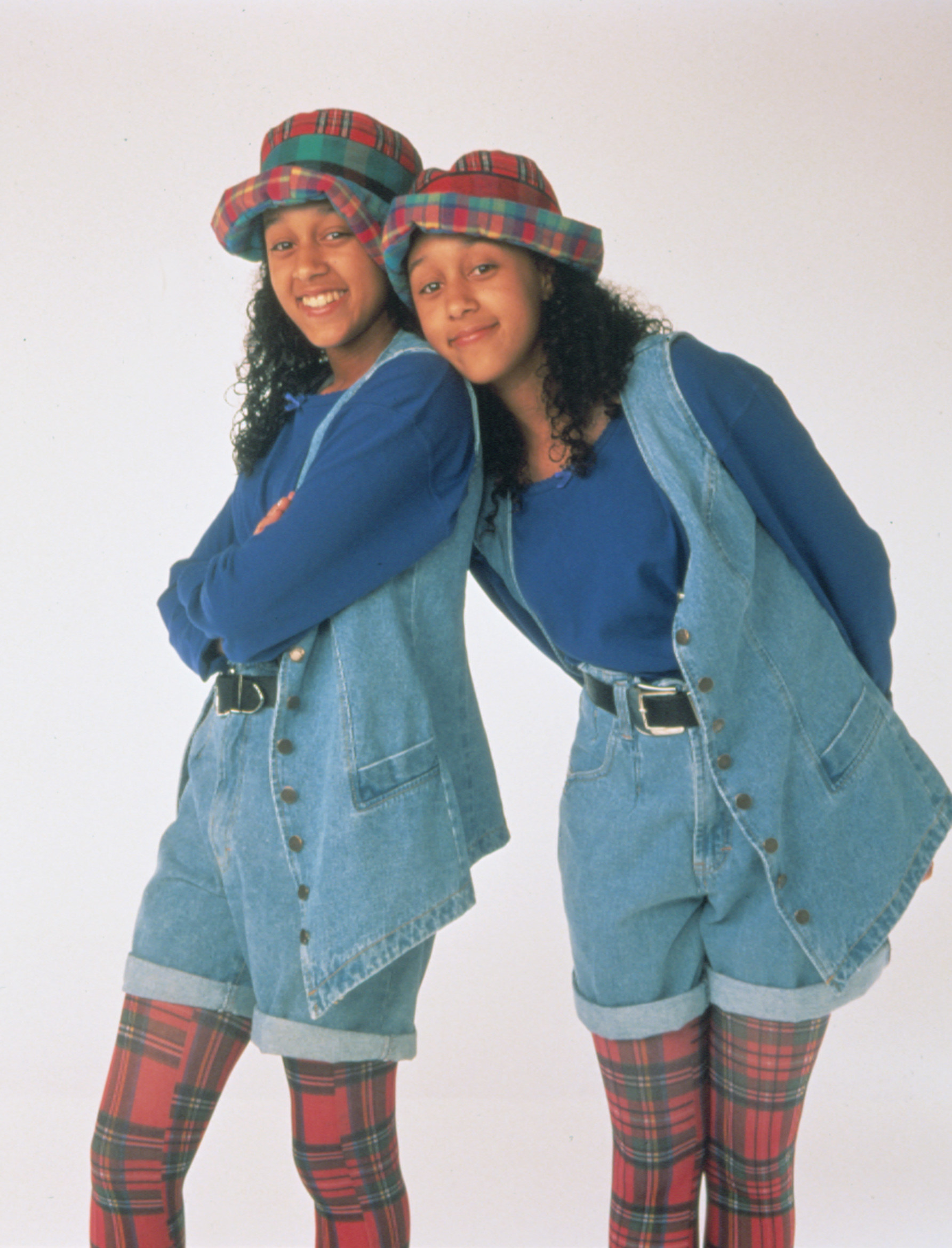 Tia and Tamera Mowry wearing denim jumpsuits and hats as their &quot;Sister, Sister&quot; characters