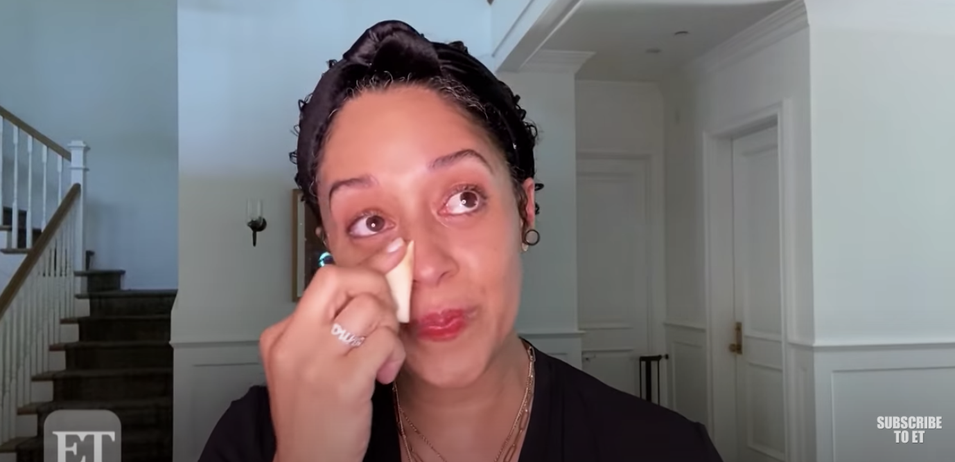 Tia wipes away her tears with a makeup sponge