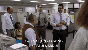 A GIF of a person smiling and saying got my skin glowing like Paula Abdul