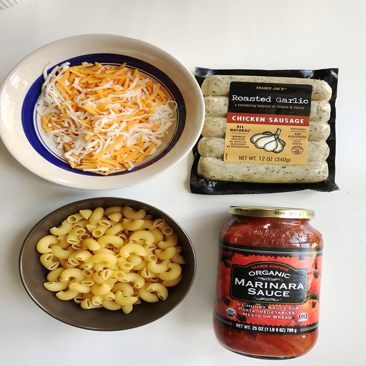 Ingredients for a microwave pasta bowl: noodles, sausage, cheese, and sauce.