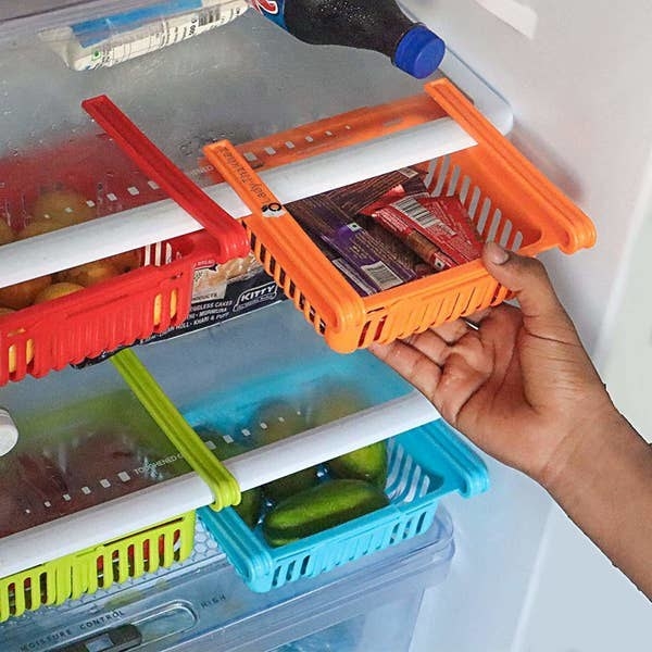 The organising racks clipped onto fridge shelves and storing chocolates, veggies, and fruits. 