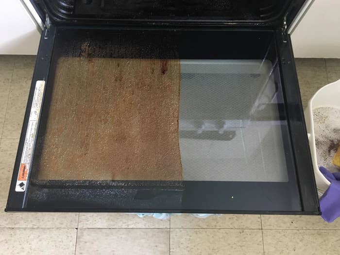 reviewer photo showing oven door revealing caked on grime on one half of it and a clean surface on the other half