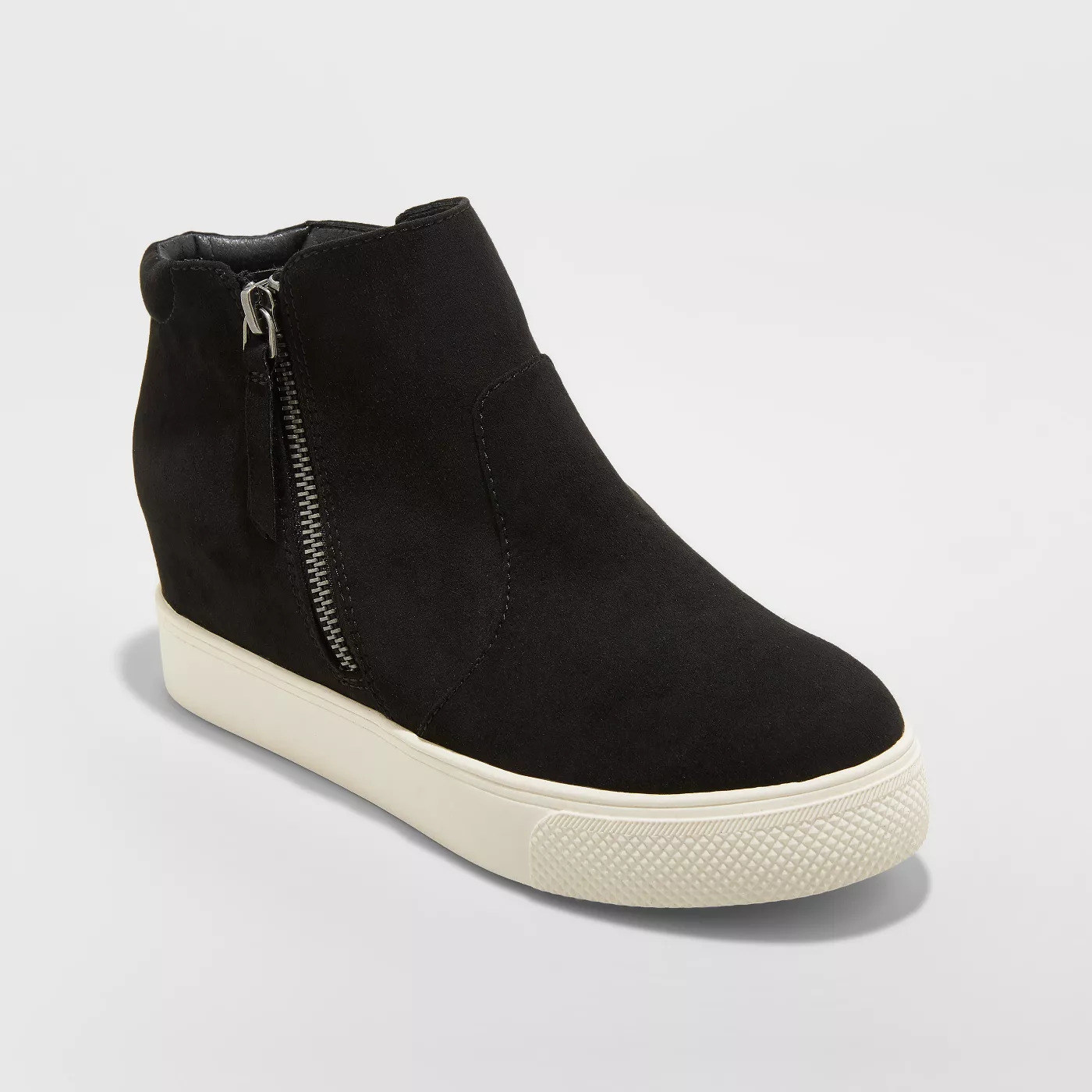 A black high top sneaker with a flat rubber sole and zipper on the side