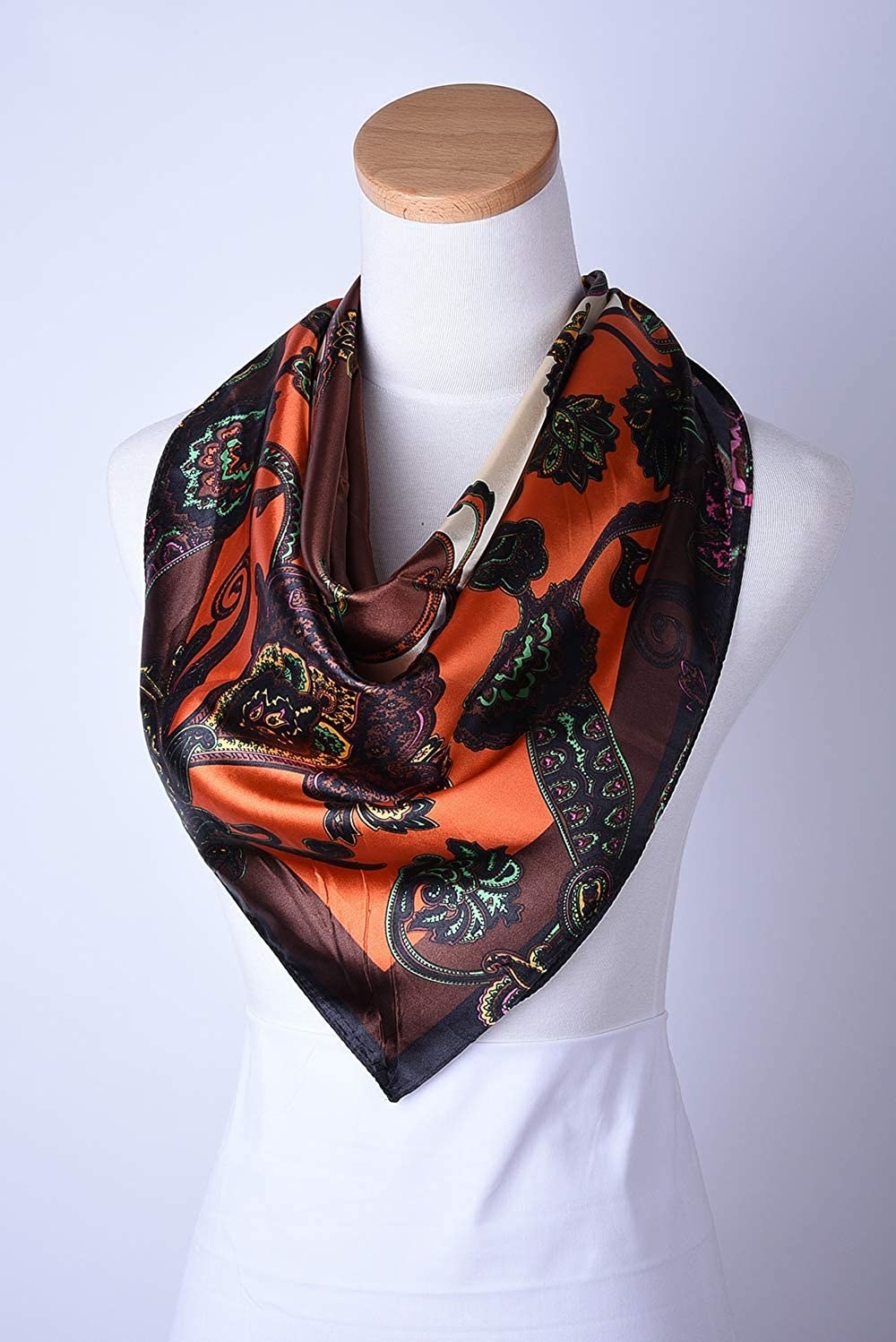 The multicolor (including orange and brown) scarf draped on a mannequin 