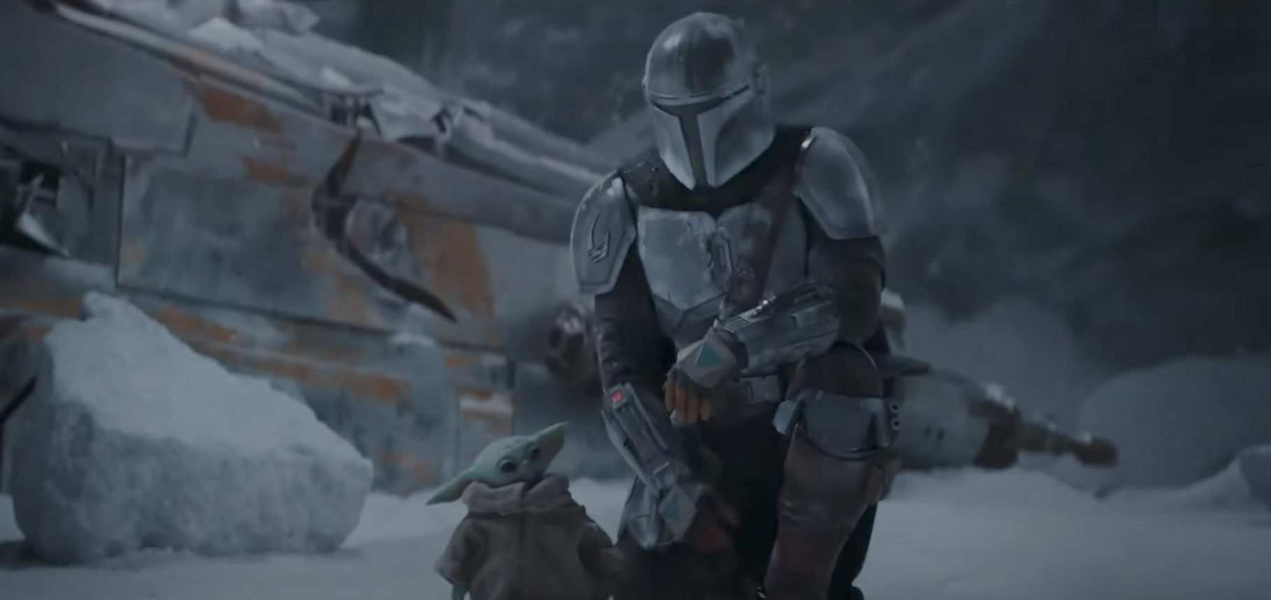 The Mandalorian kneels next to Baby Yoda