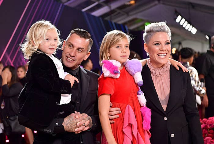 Carey Hart and Pink posing at a Hollywood event with their two children