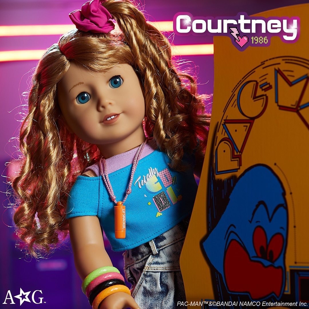 the new american girl doll playing a pac-man machine