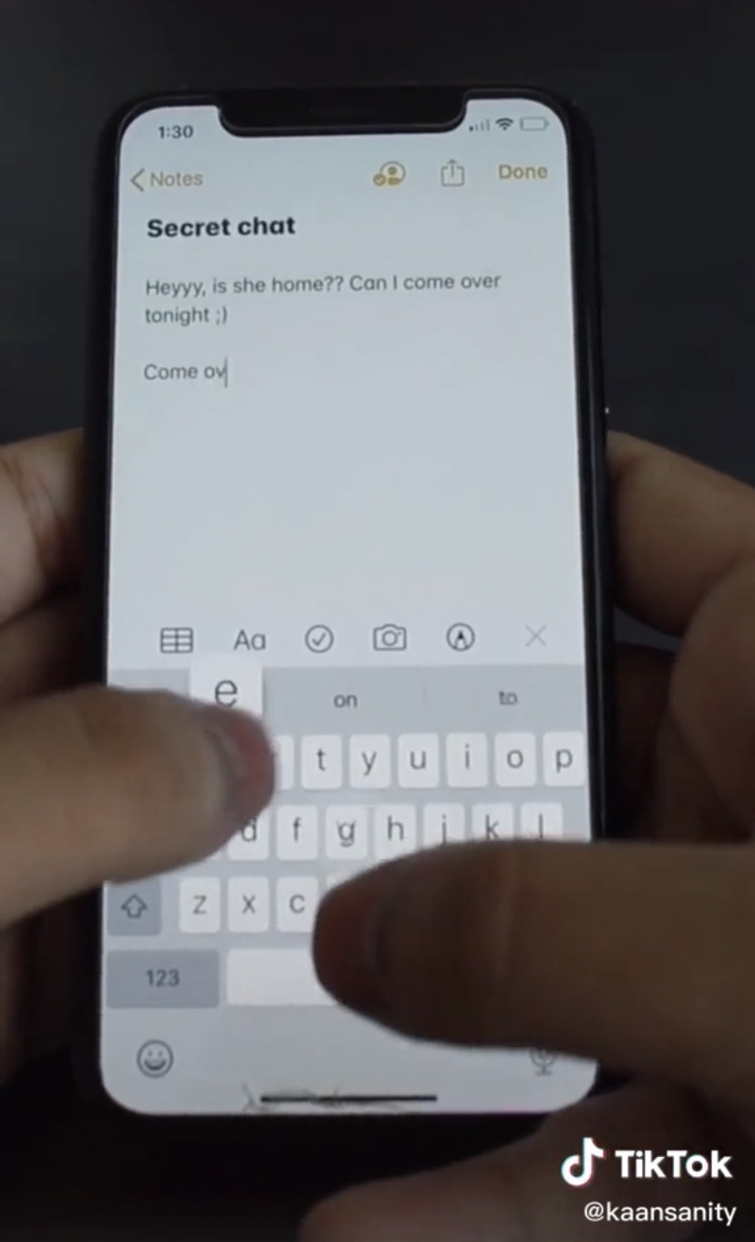 Hands typing a &quot;secret note&quot; on an iPhone