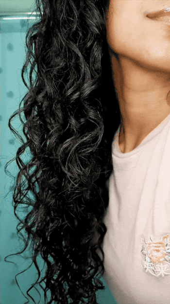 Gif of model running fingers through their curly and shiny strands