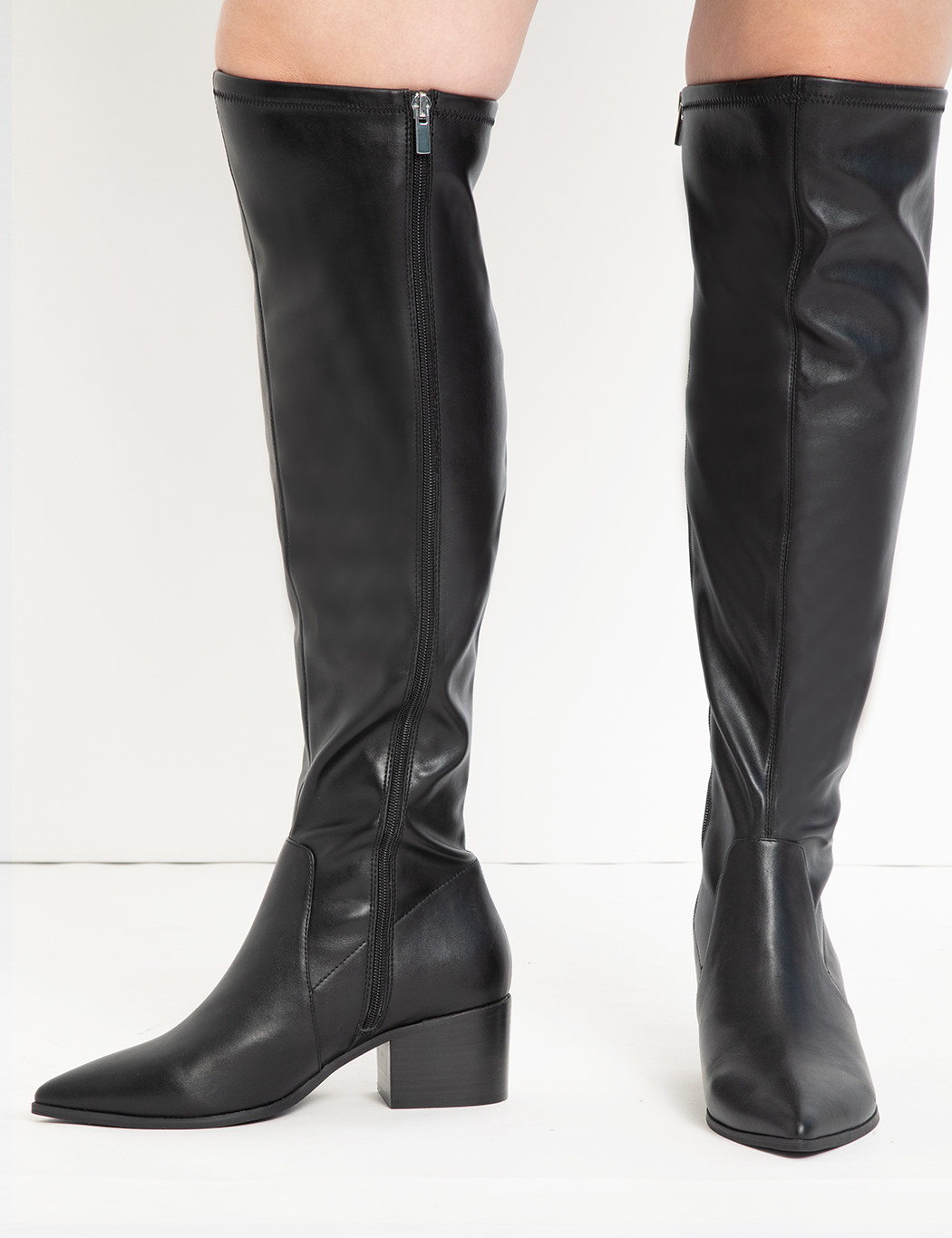 model wearing black pointed toe boots with side zipper