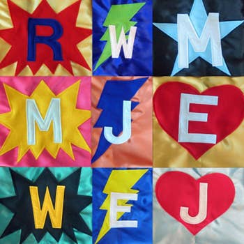 A grid of nine colorful cape designs with letters and symbols