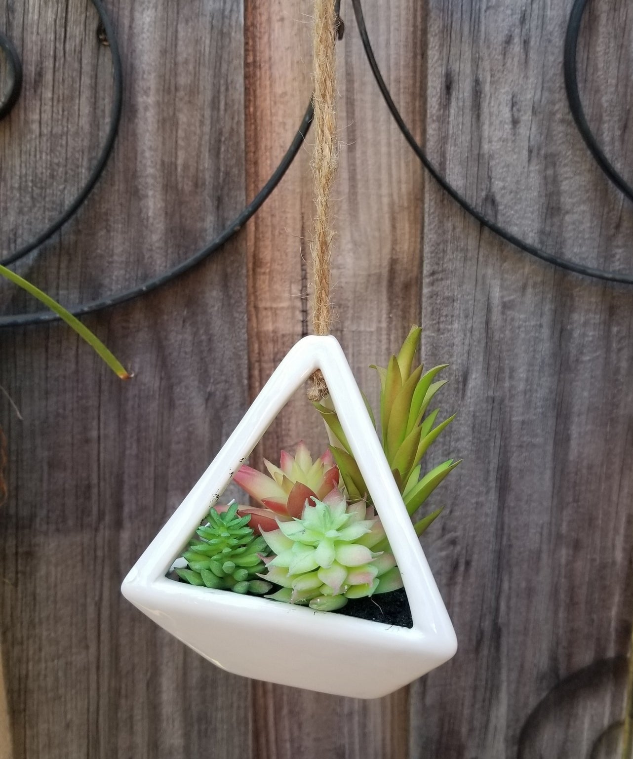 The fake succulent arrangement in a white geometric hanging pot