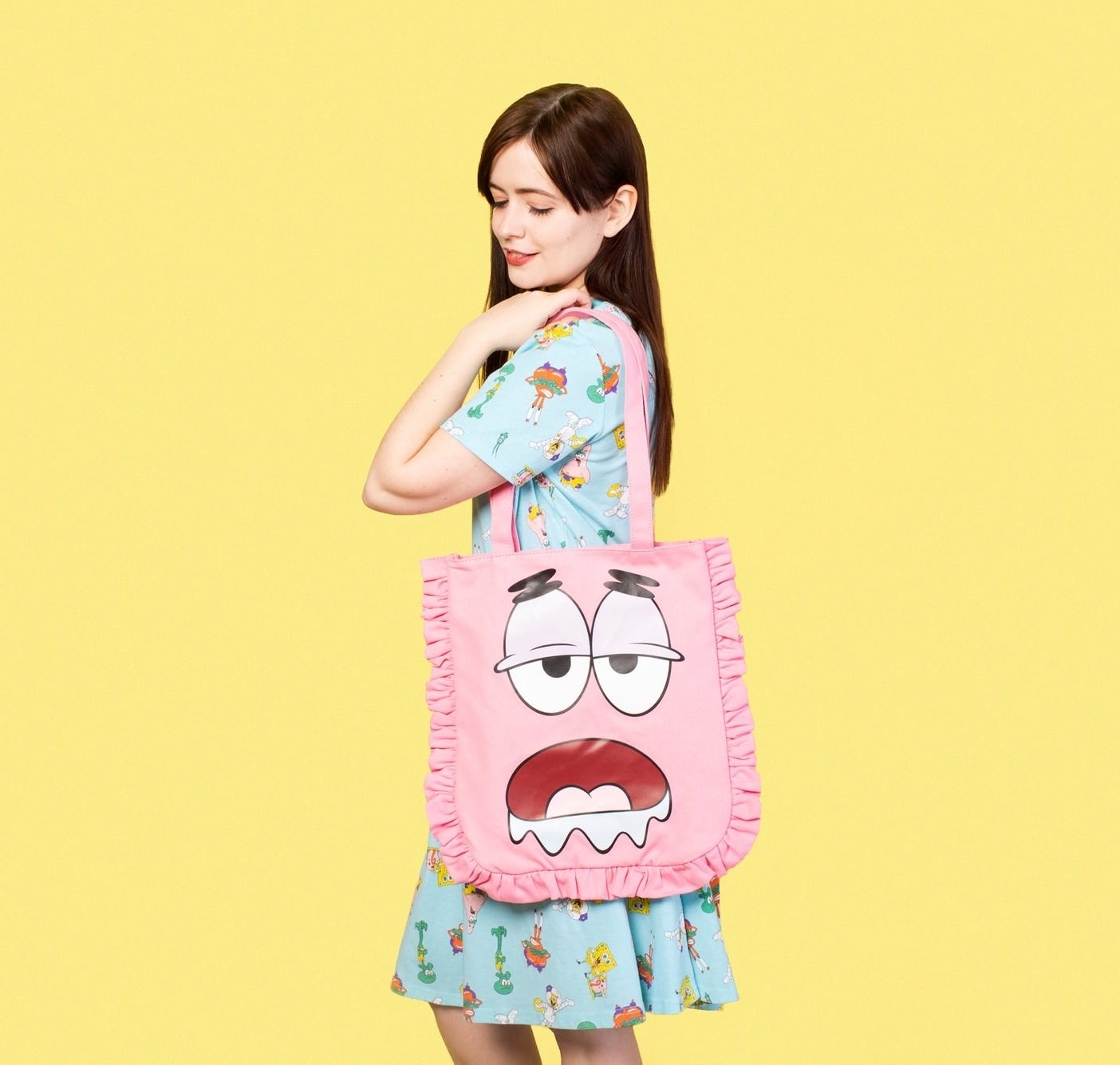 A model carrying the pink tote with ruffles around the sides and the drooling face of Patrick Star from &quot;SpongeBob&quot; emblazoned on it