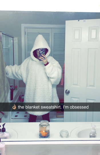 reviewer in oversized white blanket hoodie 