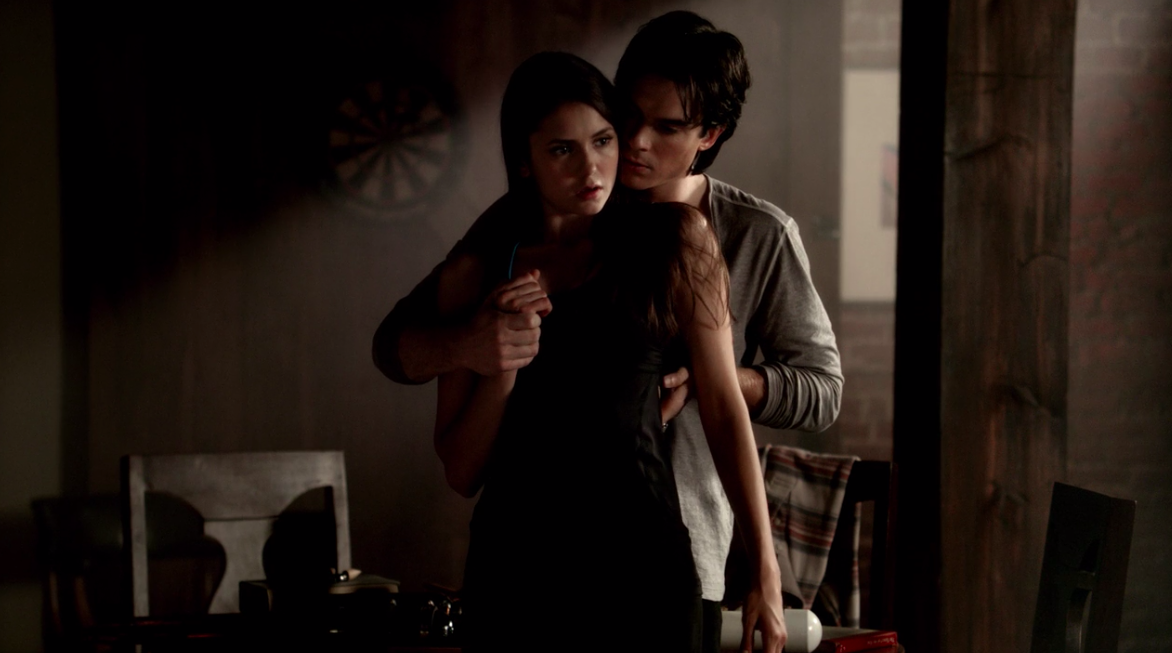 &quot;The Vampire Diaries&quot; characters Damon and Elena stand in front of each other, as he touches her back and hand