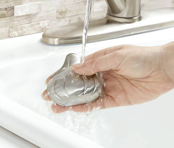A person holds a garlic shaped bar under water 