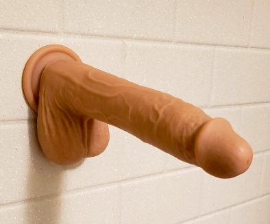 Realistic silicone dildo on shower wall 