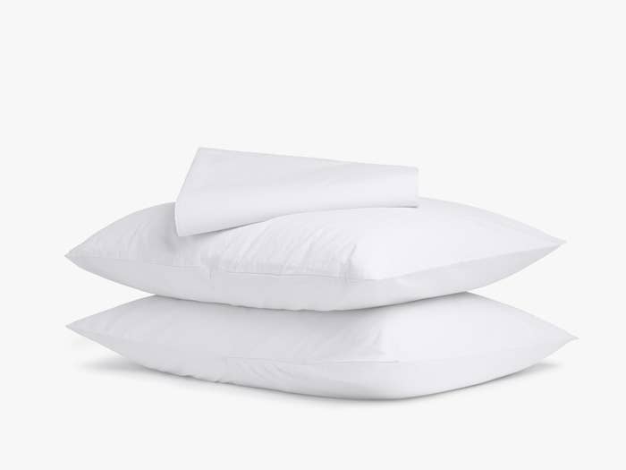 Two pillows with pillowcases plus a white sheet