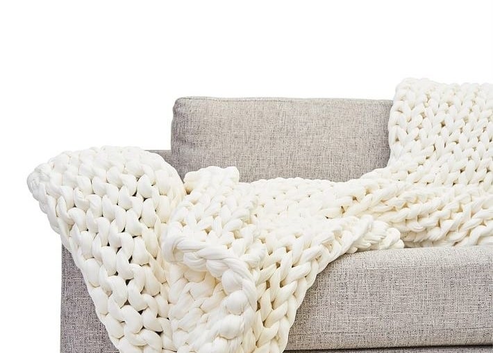 The white cotton knit blanket on a sofa