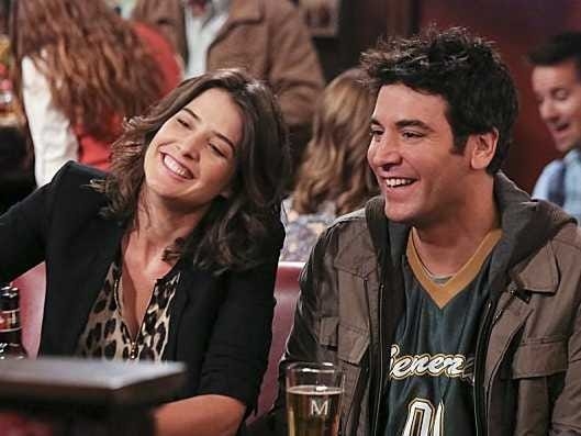 &quot;How I Met Your Mother&quot; characters Robin and Ted laughing, while sitting inside their local bar