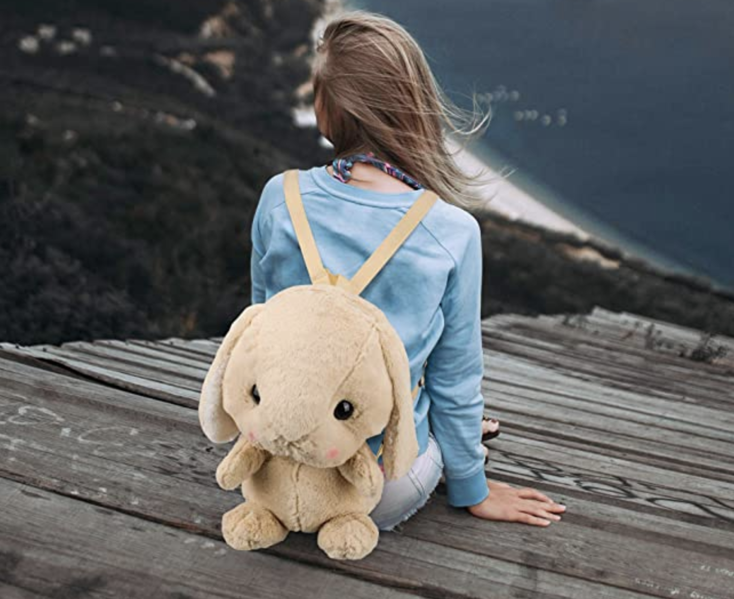 model wearing a beige plush bunny shaped backpack 