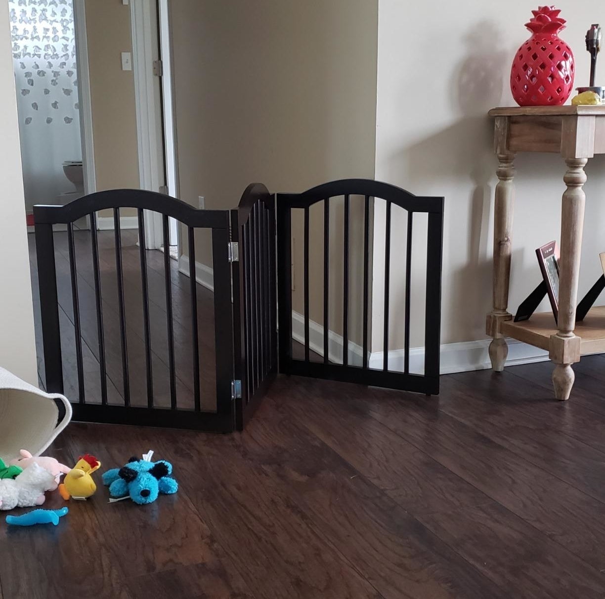 A folding gate with rounded top and wooden slats