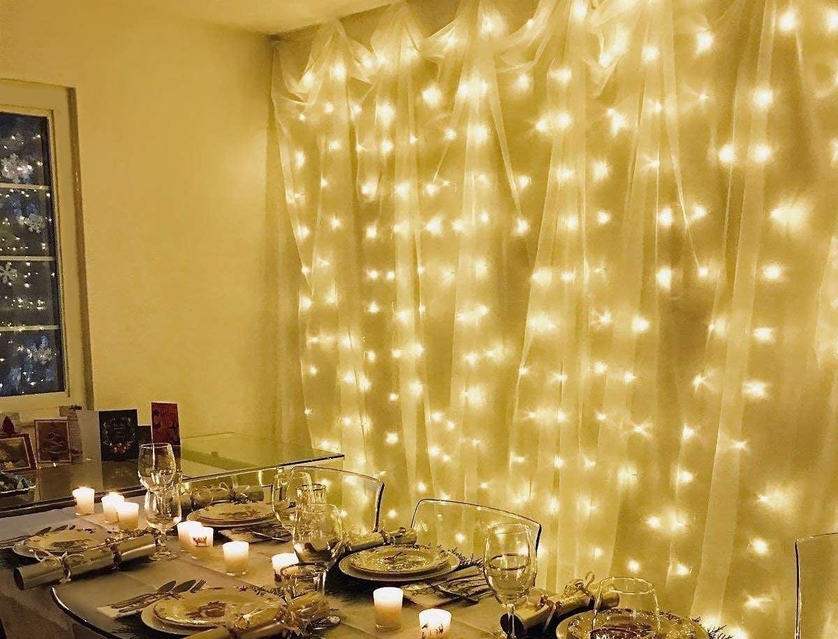 Fairy lights hung upon a wall beside a dinner table