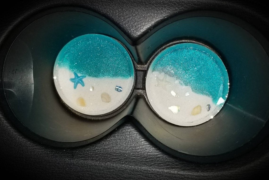 coasters in cup holders with glittery water and sand 