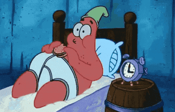 Patrick chews a Krabby Patty in bed, wearing his underwear and a night cap