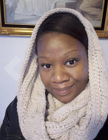 a reviewer wearing the beige scarf across her neck and head