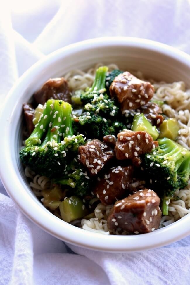 Chunks of beef and broccoli with sesame seeds over a bed of rice.