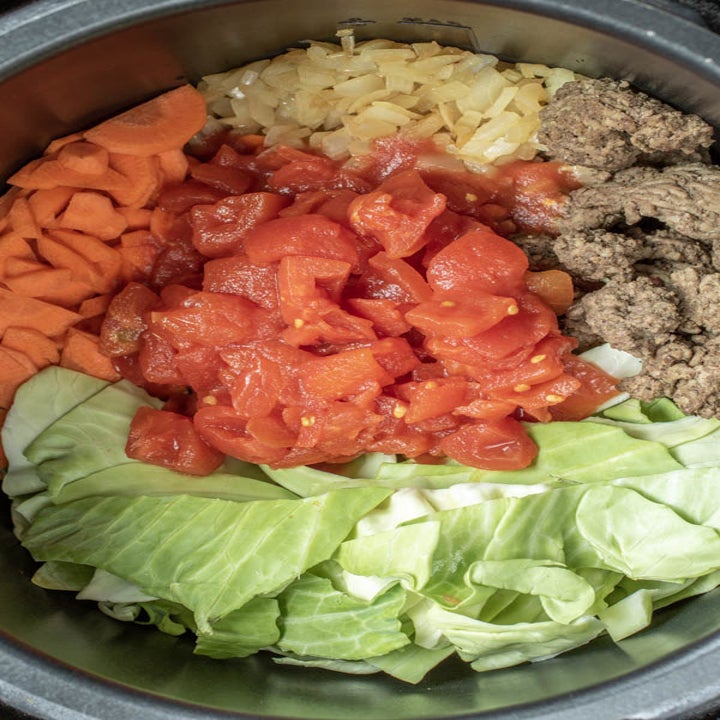 Cabbage, garlic, ground beef, and diced tomatoes in a slow cooker.
