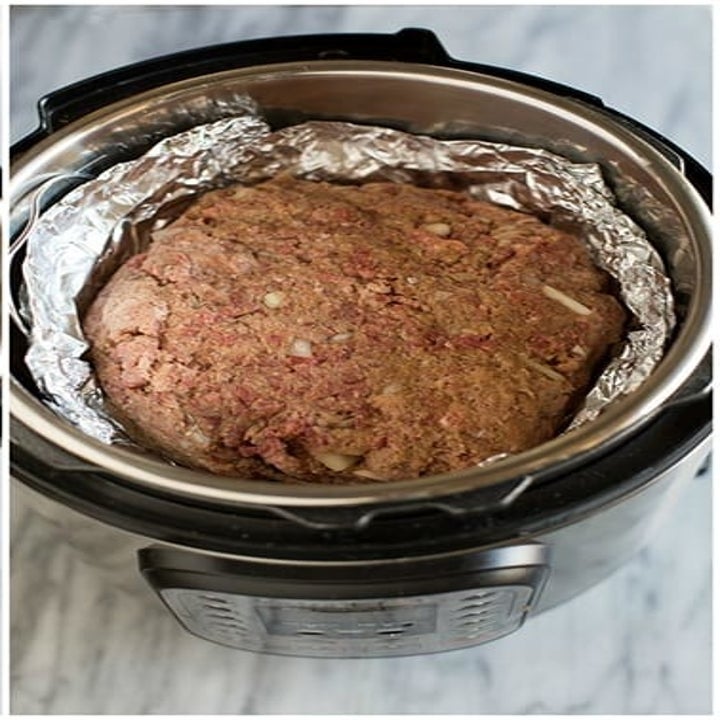A meatloaf cooking in foil in an Instant Pot.