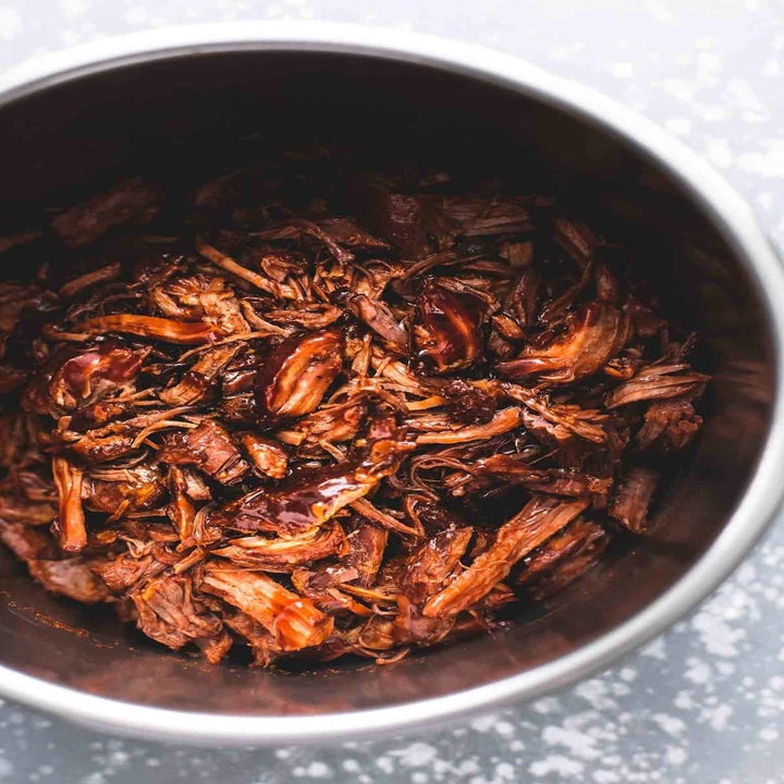 An Instant Pot filled with shredded pulled pork in BBQ sauce.