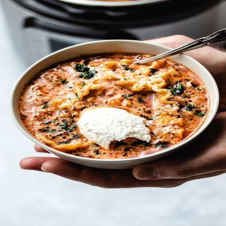 A bowl of lasagna soup with a dollop of ricotta.