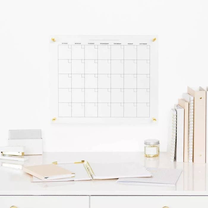The glass dry erase calendar hung above desk