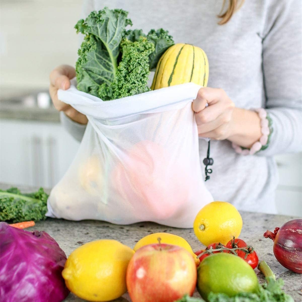 A person taking fruits and veggies out of a produce bag