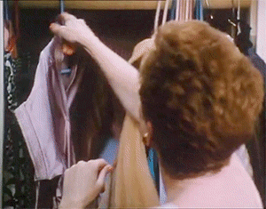 GIF of Kathleen Turner holding scissors in a closet from Serial Mom