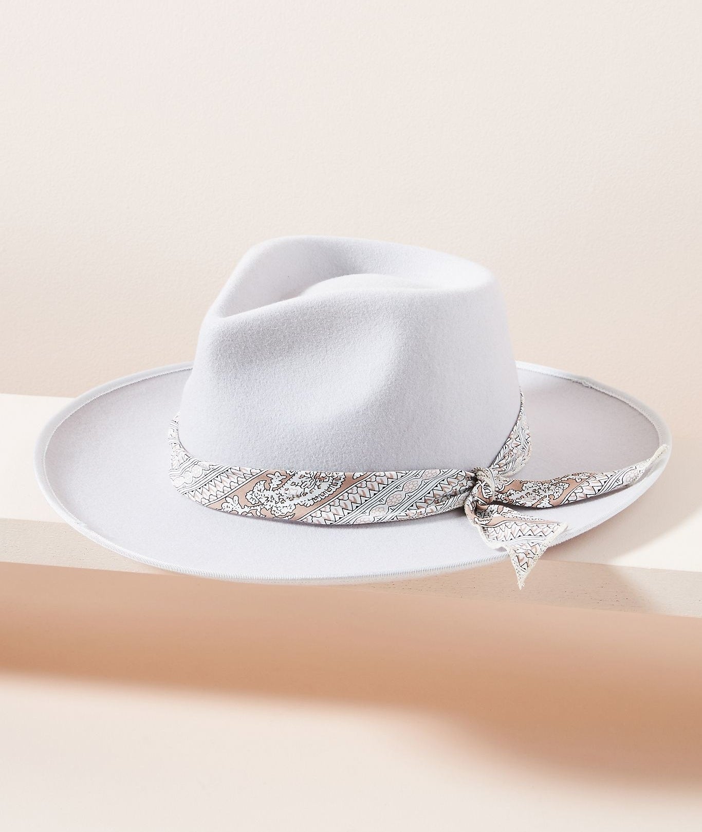 A gray-lavender fedora with a paisley bandana tied around the hat