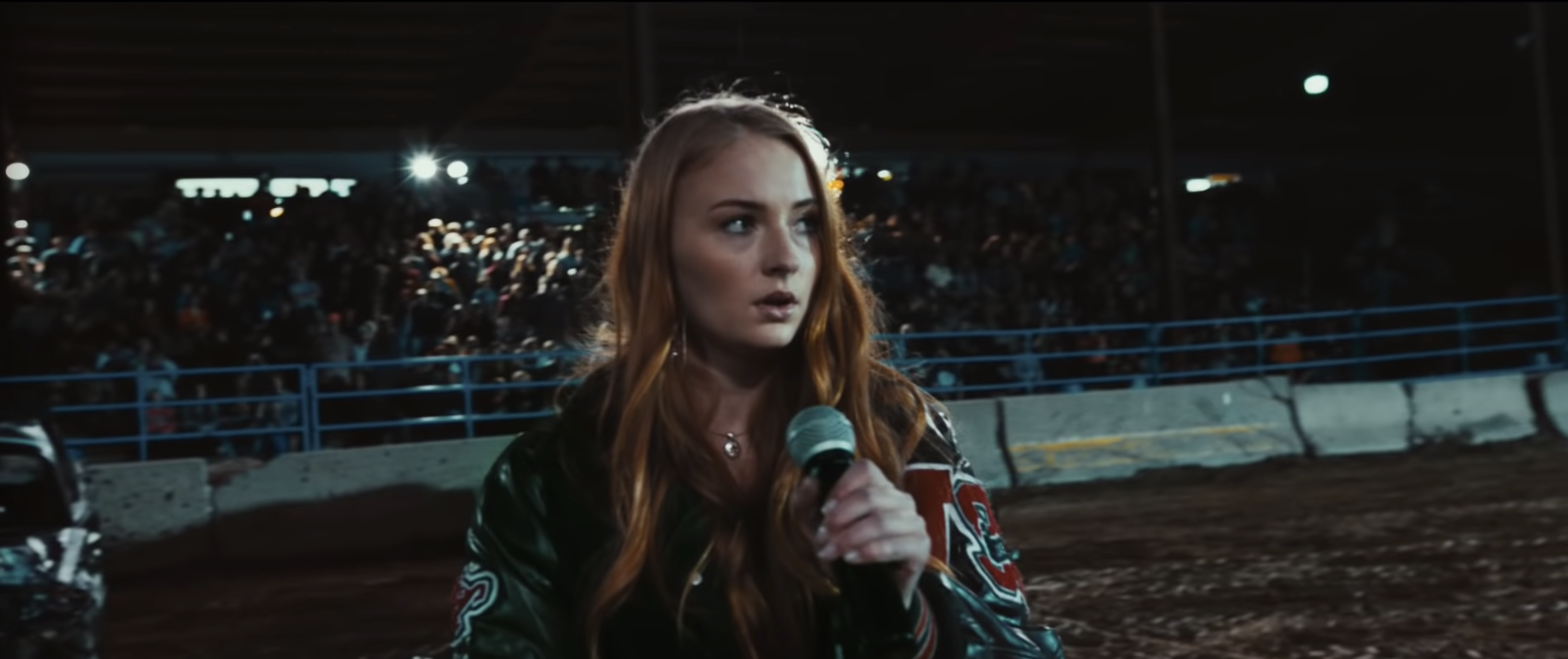 Sophie preparing to talking into a mic at a rodeo. 