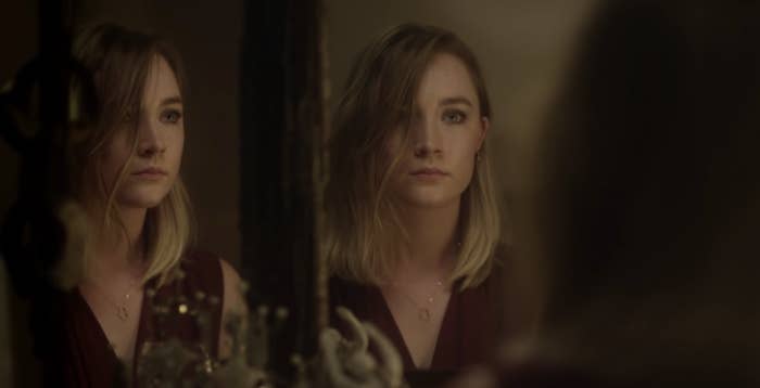 Saoirse looking at her reflection in the mirror. 