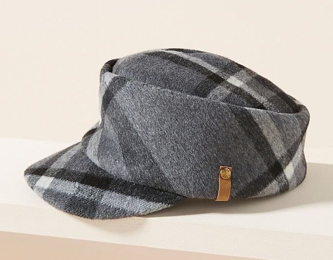 A cap with a cylindrical base and visor extended at a downward angle with a thick, plaid print