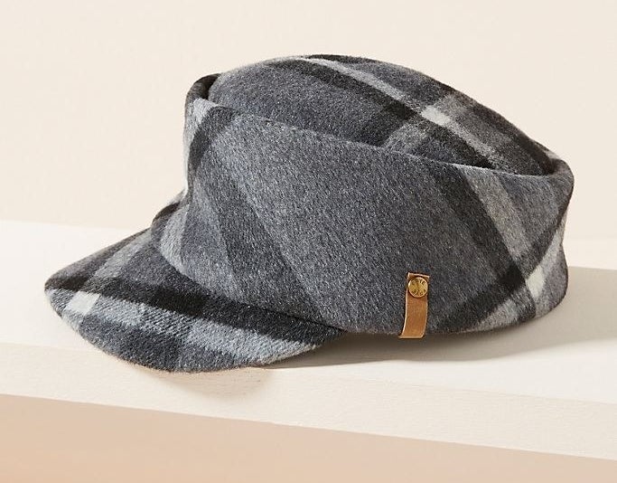 A cap with a cylindrical base and visor extended at a downward angle with a thick, plaid print